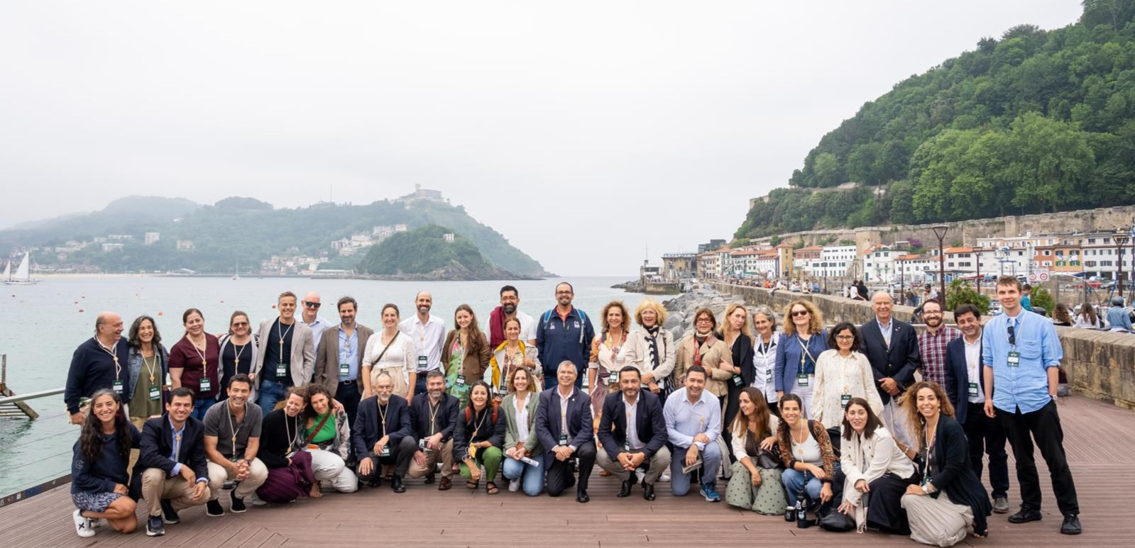 Personas posando con el mar a sus espaldas en un encuentro global.
